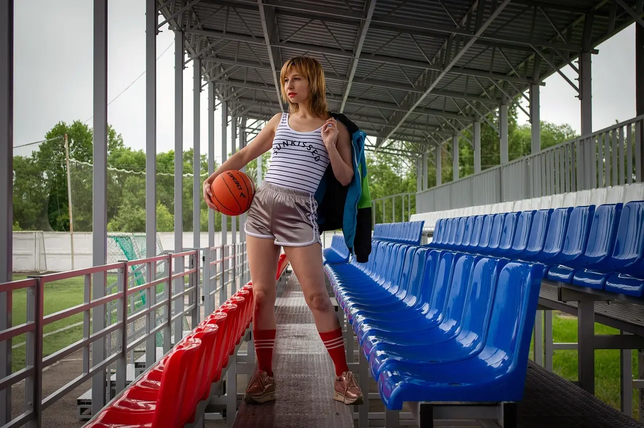 Kvinde med basketball på tom tribune